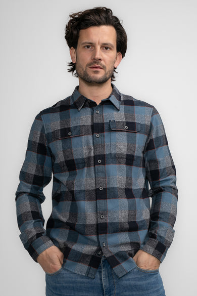Chemise à manches longues bleue à carreaux par Petrol Industries, portée avec un jean décontracté.