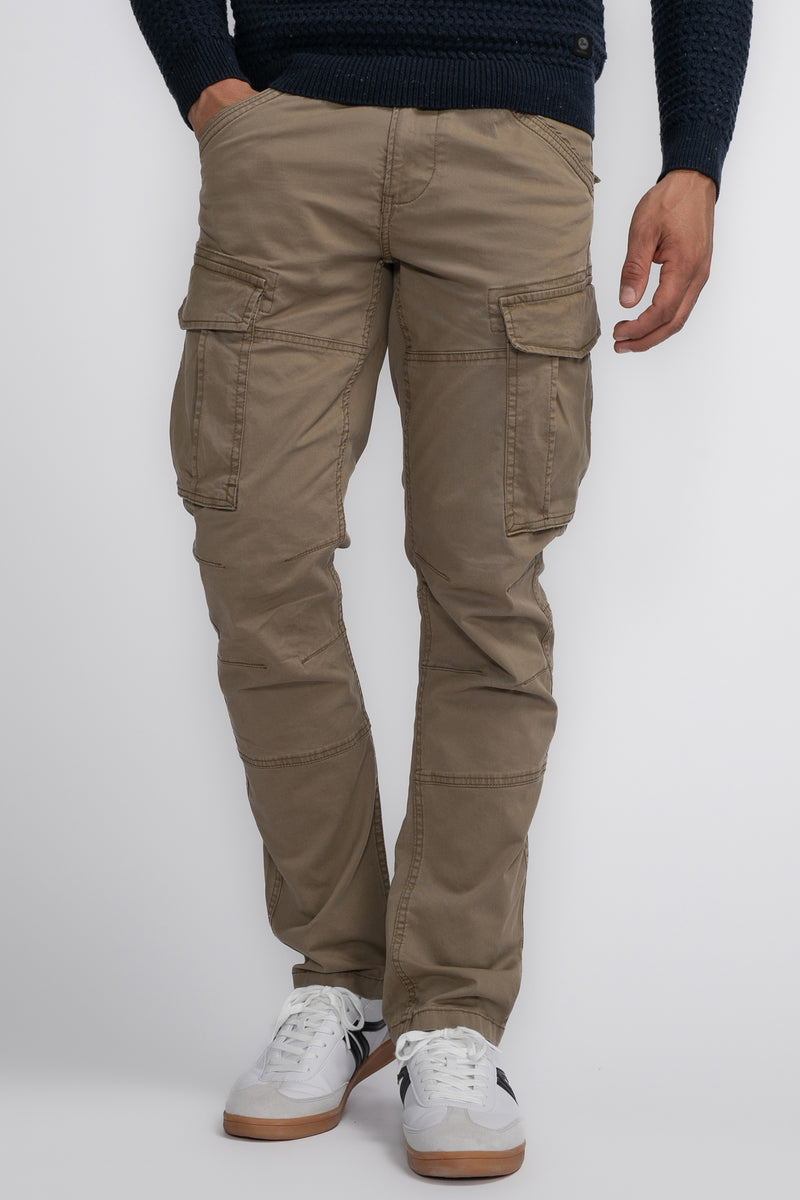 Pantalon cargo beige de Petrol Industries, porté avec un pull bleu marine et des baskets blanches.