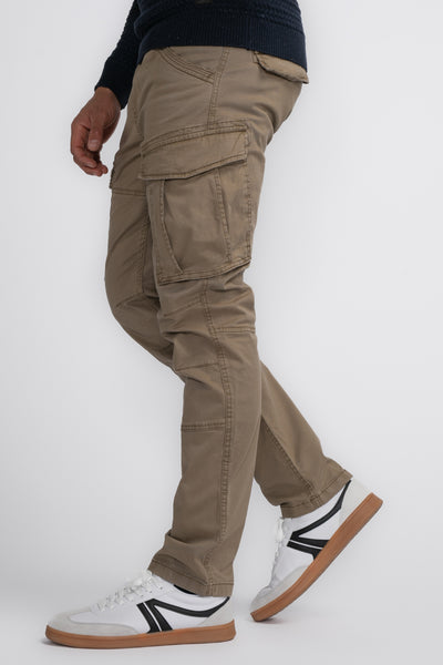 Beige cargobroek van Petrol Industries, met cargozakken en decoratieve stiksels, gedragen met een marineblauwe trui en witte sneakers.