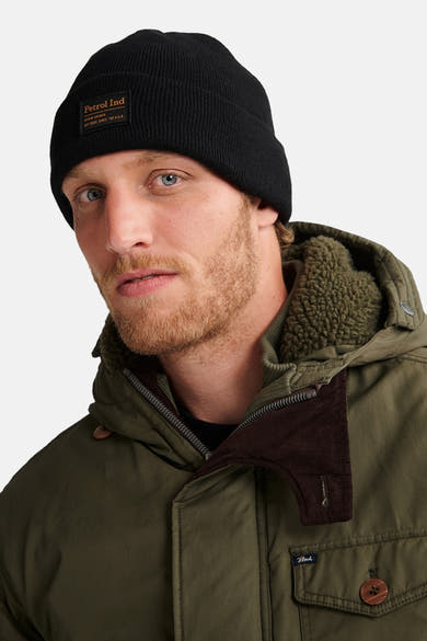 Zwarte muts van Petrol Industries, gedragen met een kaki parka met sherpa kraag en corduroy details.