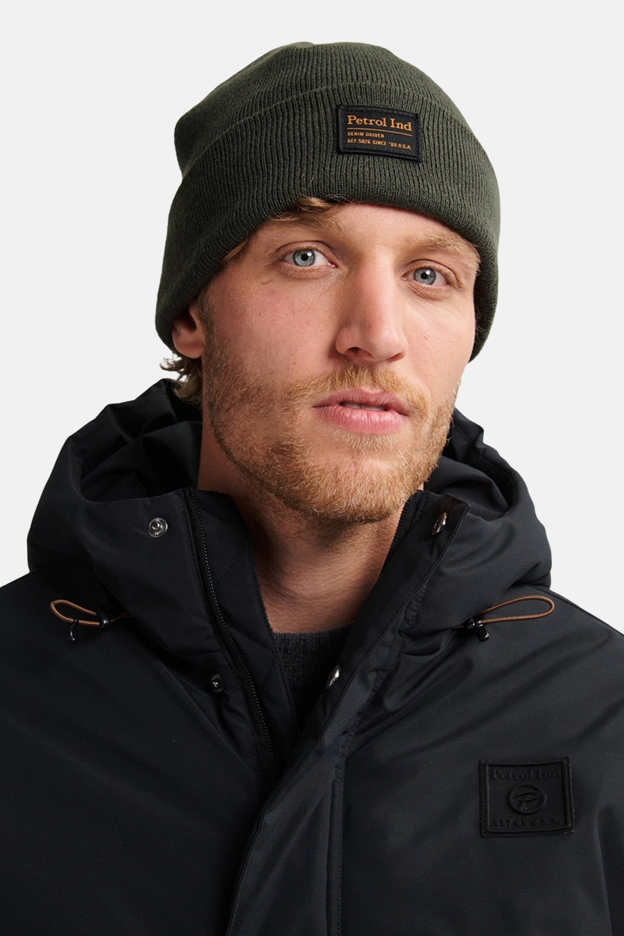 Donkergroene muts van Petrol Industries, in ribgebreid, gedragen met een zwarte hoodie.