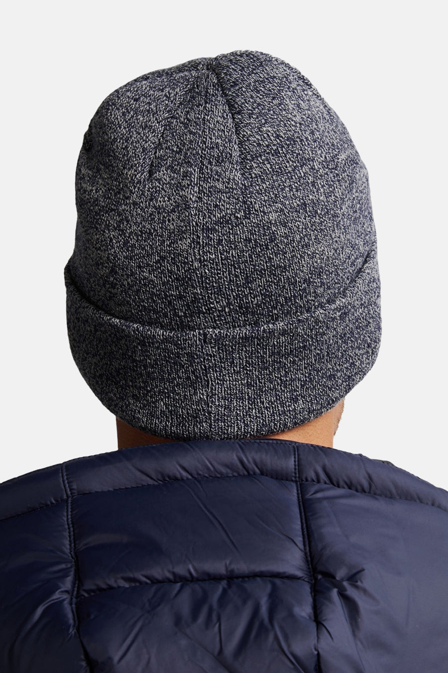 Bonnet bleu chiné de Petrol Industries, porté avec une veste matelassée bleu marine, vue de dos.