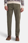 Pantalon vert en velours côtelé par Petrol Industries, porté avec un pull à motifs hivernaux et des bottines en cuir.