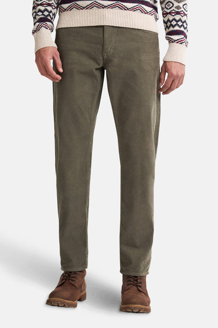 Groene corduroy broek van Petrol Industries, gedragen met een trui met winterpatroon en leren enkellaarsjes.