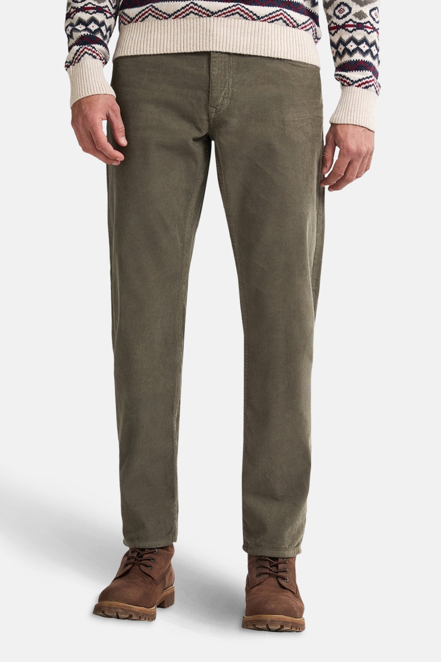 Pantalon vert en velours côtelé par Petrol Industries, porté avec un pull à motifs hivernaux et des bottines en cuir.