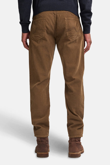 Beige ribfluwelen broek van Petrol Industries, met zichtbare achterzakken en bruine enkellaarsjes.