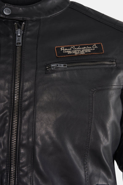Veste courte noire en similicuir de Petrol Industries, avec fermeture éclair apparente et badge décoratif.