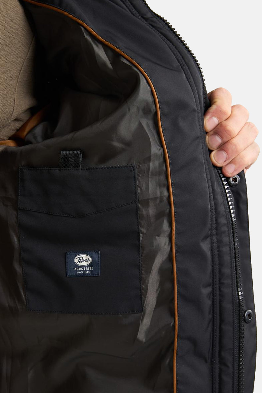Veste de pluie noire par Petrol Industries, avec poche intérieure et doublure marron.