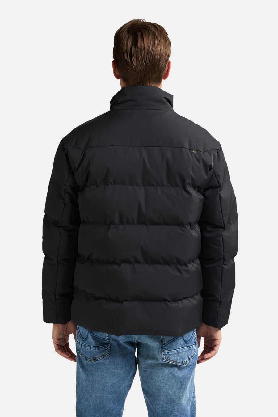 Veste de pluie noire de Petrol Industries®, vue de dos, portée avec un jean bleu.