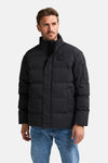 Veste de pluie noire de Petrol Industries avec fermeture éclair et détails matelassés, portée avec un jean bleu.