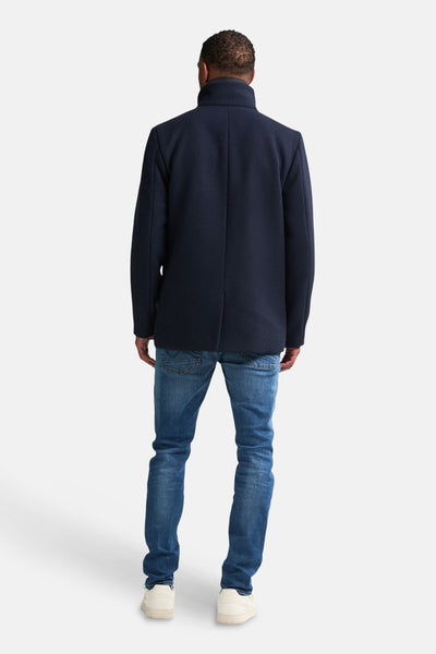 Marineblauwe jas van Petrol Industries, achteraanzicht, gedragen met een blauwe jeans en witte sneakers.