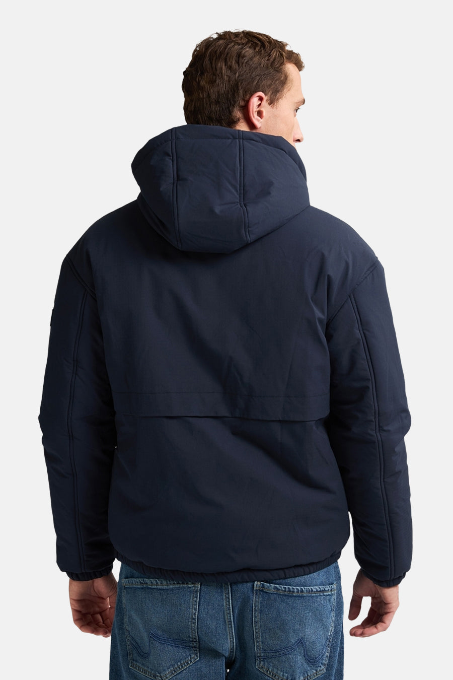 Veste courte bleue par Petrol Industries, avec capuche et coupe décontractée, portée avec un jean visible de dos.