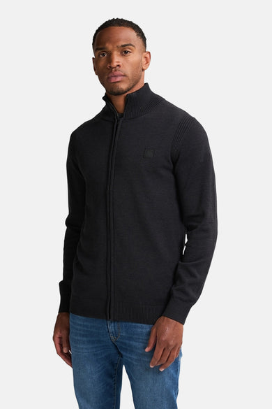 Zwart vest met ritssluiting van Petrol Industries, gedragen met een blauwe jeans.
