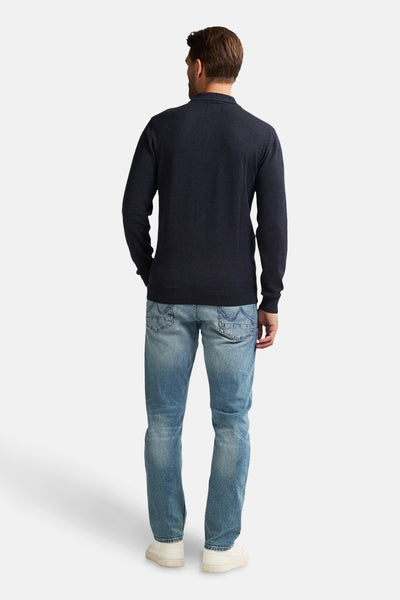 Blauwe coltrui van Petrol Industries, gedragen met een verbleekte spijkerbroek en witte sneakers, achtergezicht.
