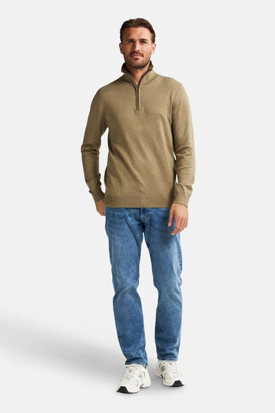 Beige trui met ronde hals van Petrol Industries, gedragen met een blauwe jeans en witte sportschoenen.