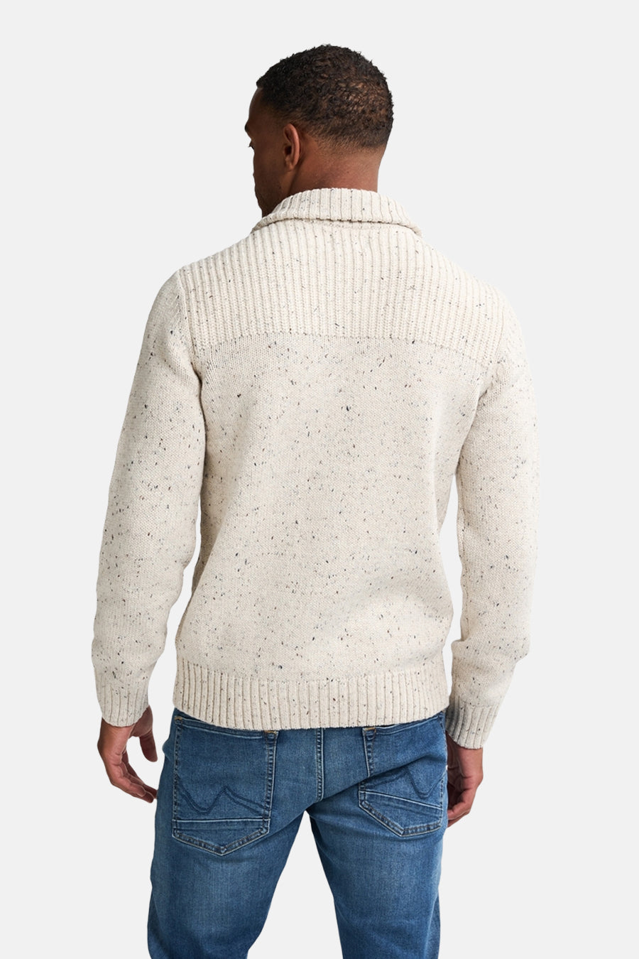 Pull écru de Petrol Industries, en maille texturée avec col châle, porté avec un jean bleu.