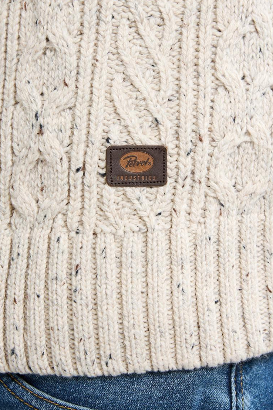 Pull écru de Petrol Industries, en maille torsadée mouchetée, avec un patch logo en cuir sur le devant.