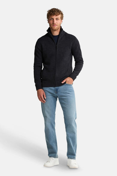 Zwart gewatteerd vest met rits van Petrol Industries, gedragen met een casual spijkerbroek en witte sneakers.