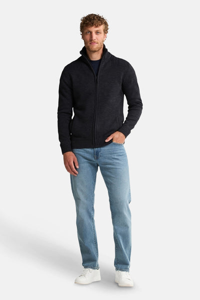 Zwart gewatteerd vest met rits van Petrol Industries, gedragen met een casual spijkerbroek en witte sneakers.