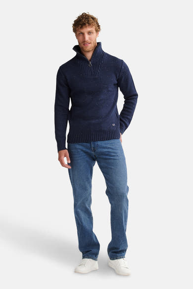 Blauwe trui met ronde hals van Petrol Industries, gedragen met een spijkerbroek en witte sneakers.