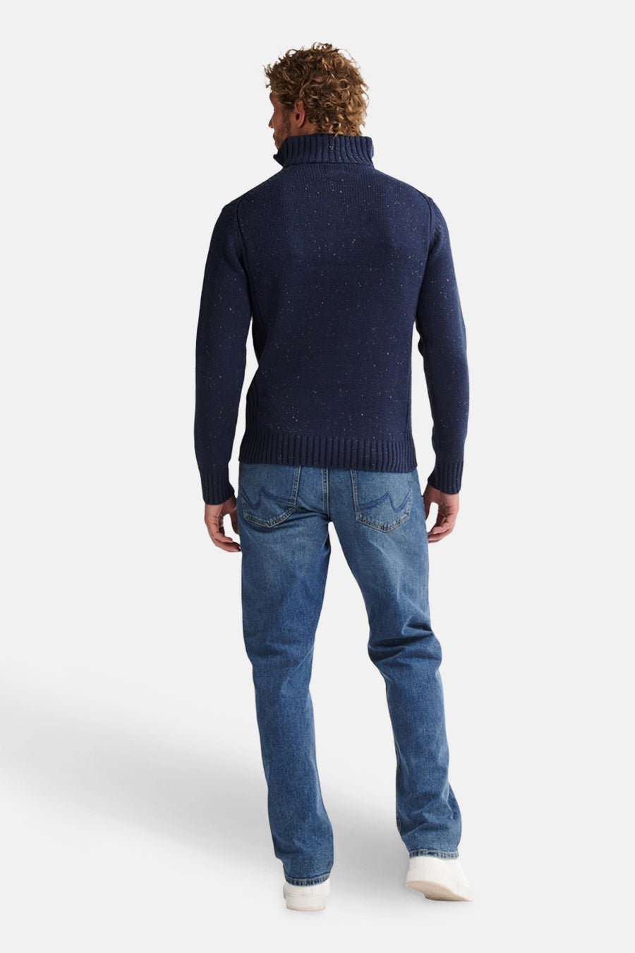 Ronde hals trui blauw van Petrol Industries, van achteren gezien, gedragen met een spijkerbroek en witte schoenen.