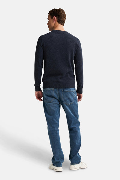 Ronde hals trui blauw van Petrol Industries, gedragen met een blauwe jeans en witte sneakers, achterzicht.