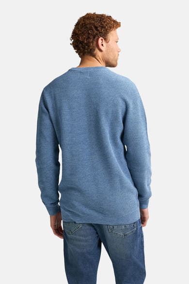 Ronde hals trui blauw van Petrol Industries, met een wafelgebreide textuur en een man die een spijkerbroek draagt.