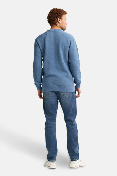 Ronde hals trui blauw van Petrol Industries, wafelstructuur, gedragen met een spijkerbroek en sneakers, achterzicht.