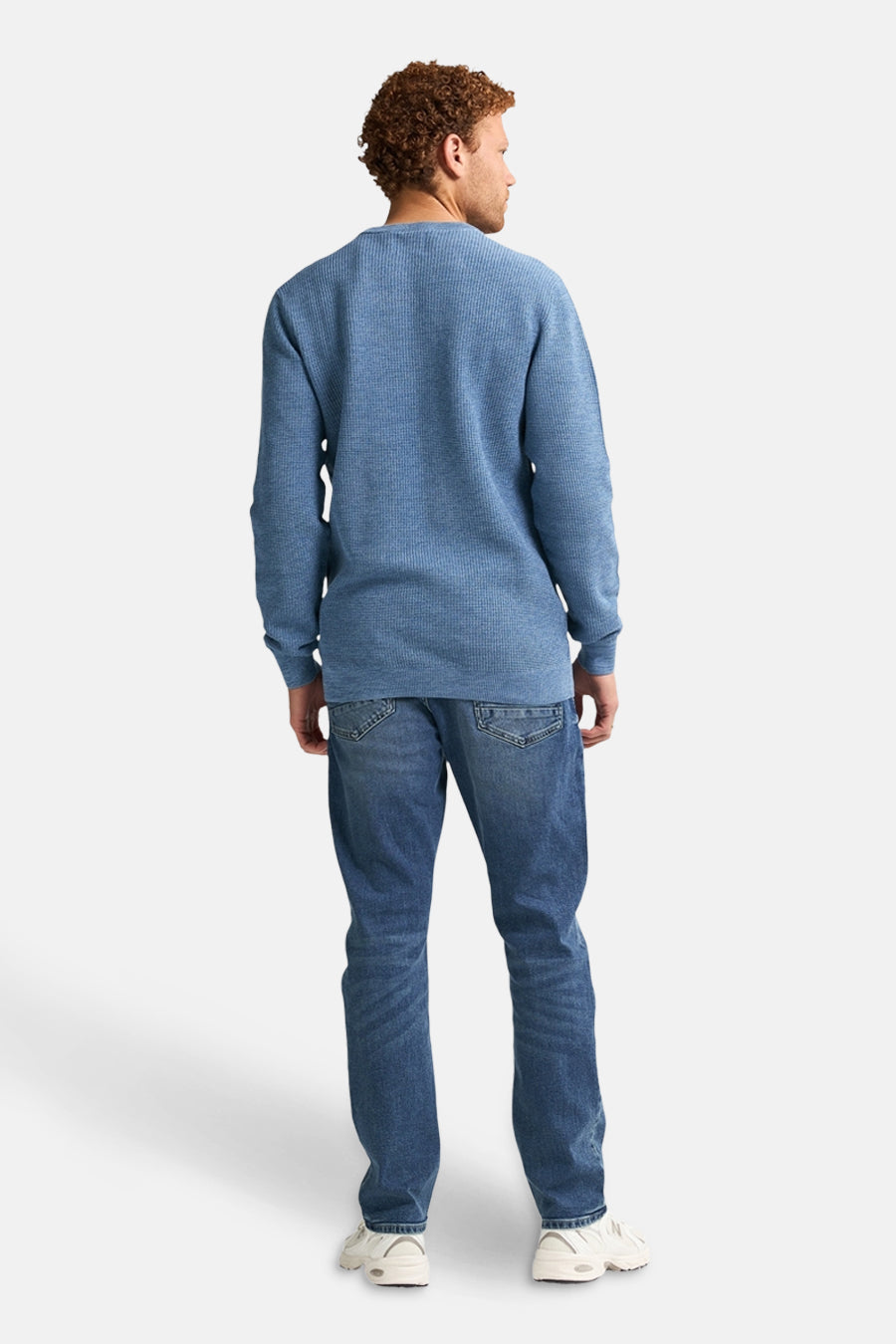 Ronde hals trui blauw van Petrol Industries, wafelstructuur, gedragen met een spijkerbroek en sneakers, achterzicht.