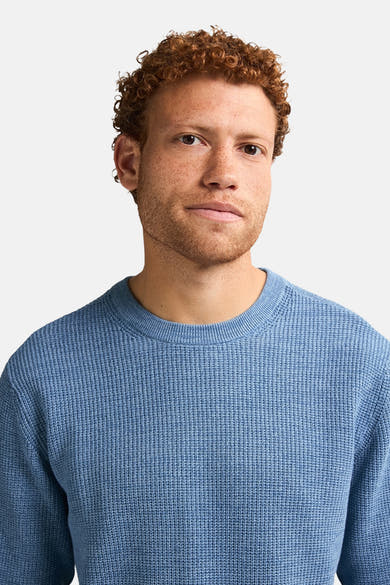 Ronde hals trui blauw van Petrol Industries, in ribgebreid, gedragen door een man met rood haar.