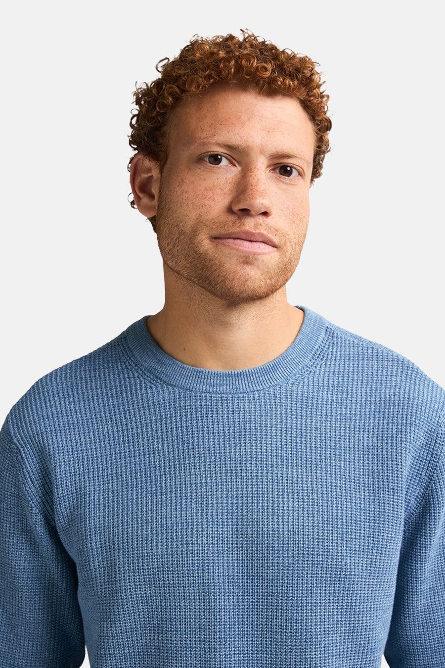 Ronde hals trui blauw van Petrol Industries, in ribgebreid, gedragen door een man met rood haar.