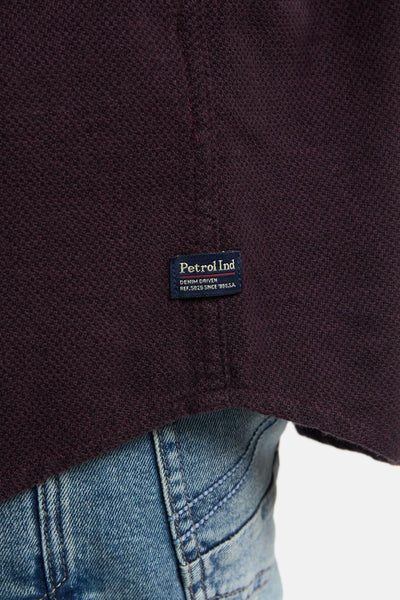 Chemise à manches longues bordeaux de Petrol Industries, avec l'étiquette de la marque visible et un jean porté.