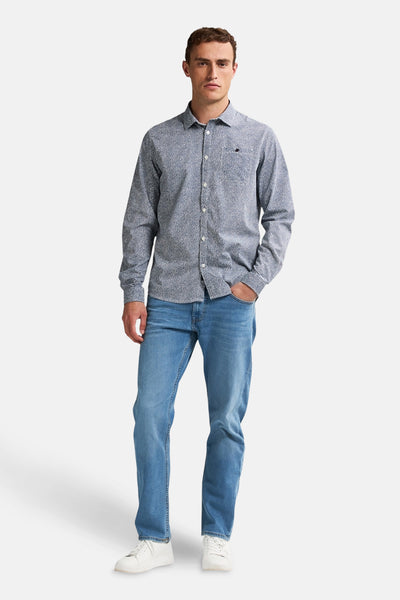 Chemise à manches longues bleue de Petrol Industries®, à motif imprimé, portée avec un jean et des baskets blanches.
