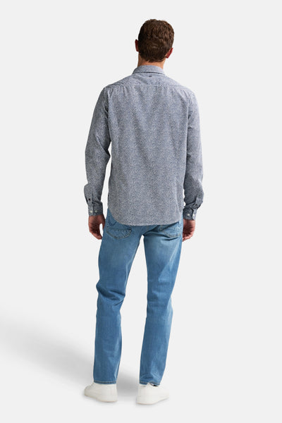 Chemise à manches longues bleue à motifs de Petrol Industries, portée avec un jean bleu et des chaussures blanches, vue de dos.
