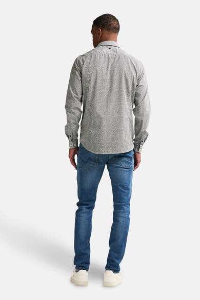 Groen overhemd met lange mouwen en patroon, van Petrol Industries, met een blauwe jeans en witte sneakers.