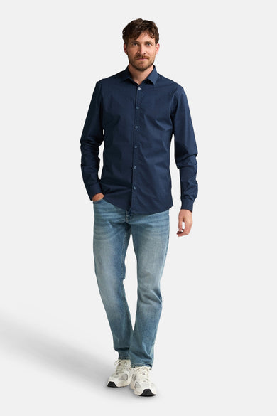 Blauw overhemd met lange mouwen van Petrol Industries® met subtiel patroon, gedragen met een spijkerbroek en sneakers.