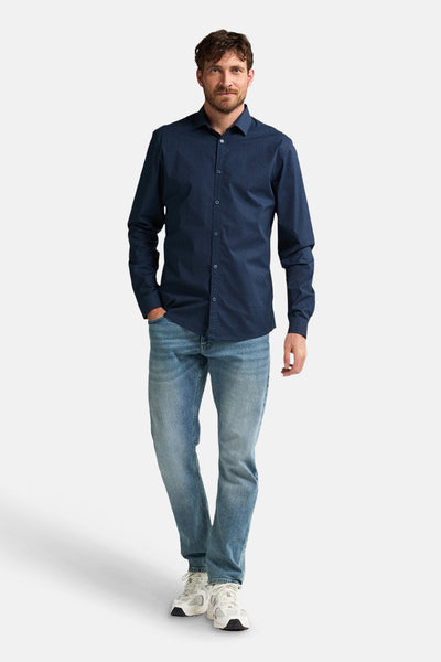 Blauw overhemd met lange mouwen van Petrol Industries® met subtiel patroon, gedragen met een spijkerbroek en sneakers.