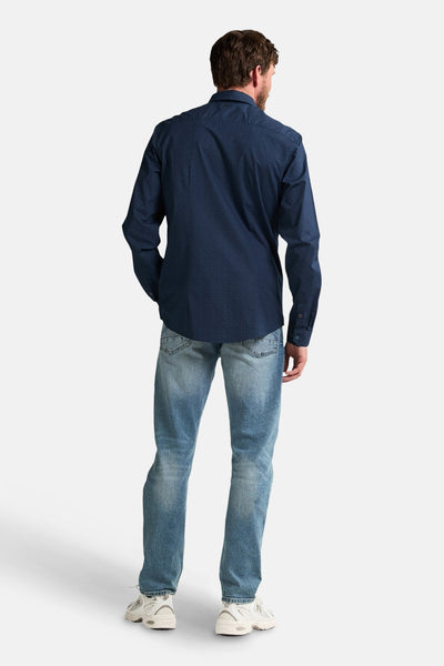 Blauw overhemd met lange mouwen van Petrol Industries®, met subtiel patroon, gedragen met een blauwe spijkerbroek en witte sneakers, van achteren gezien.