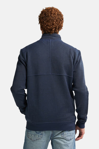 Blauwe bodywarmer van Petrol Industries, achterkant, met getextureerde details en moderne pasvorm gedragen over een spijkerbroek.