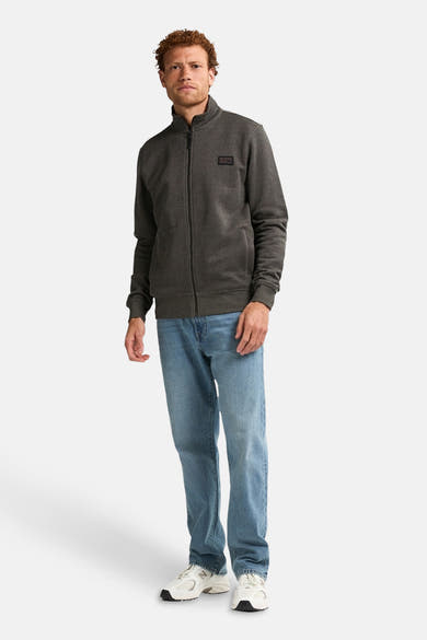 Kaki gilet van Petrol Industries, gedragen met een lichtblauwe jeans en witte sneakers.