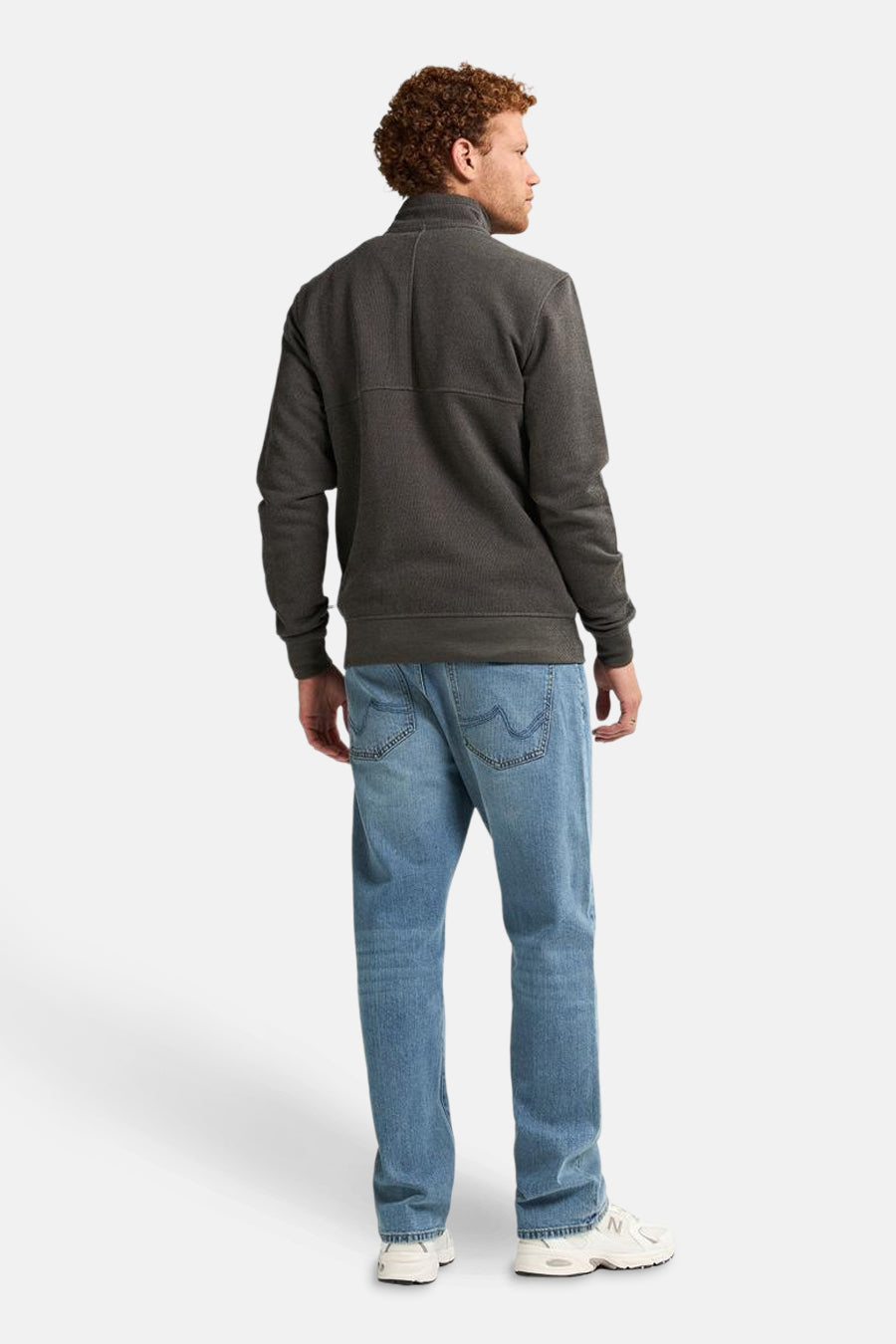 Kaki gilet van Petrol Industries, gedragen met een lichtblauwe jeans en witte sneakers.