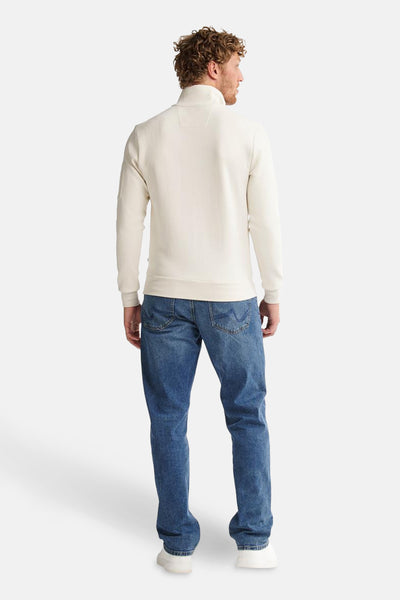 Ecru sweatshirt met opstaande kraag van Petrol Industries, met lange mouwen en gedragen met een blauwe jeans.