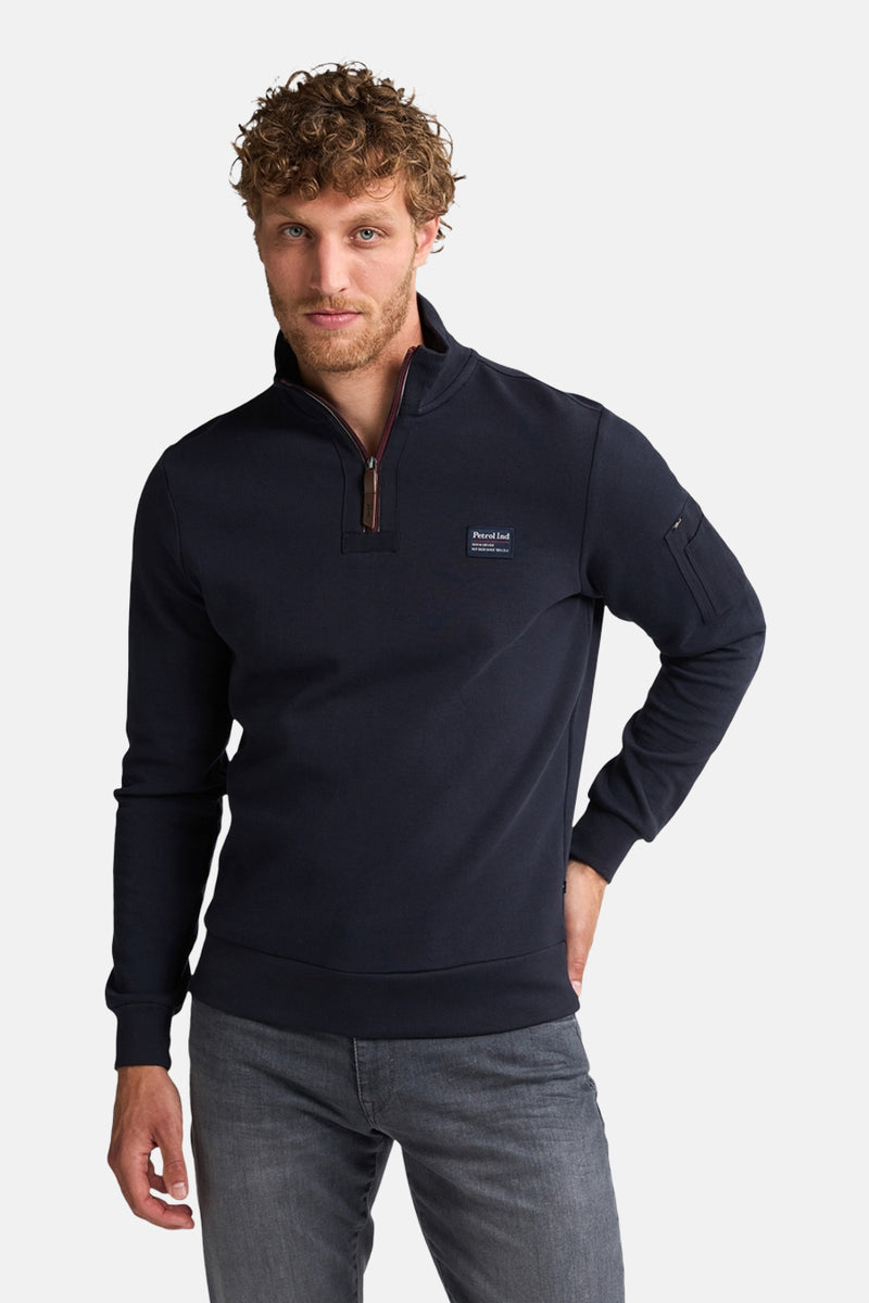 Blauwe sweater met opstaande kraag van Petrol Industries, met ritssluiting tot halverwege en zak op de mouw.