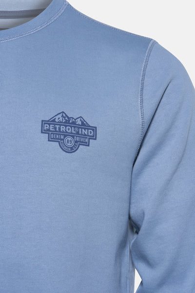 Sweat-shirt bleu à col rond de Petrol Industries, avec un imprimé décoratif sur la poitrine.