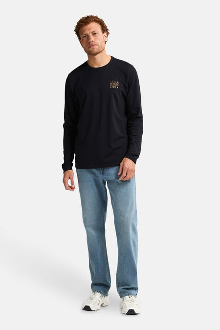 Zwart T-shirt met lange mouwen van Petrol Industries, gedragen met een blauwe jeans en witte sneakers