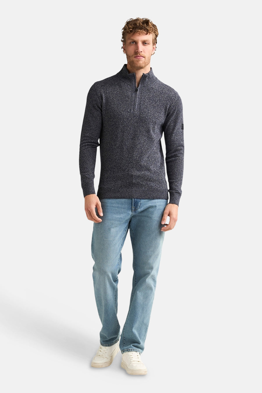 Blue marled knit half-zip sweater with ribbed cuffs and collar, worn by model in full-length lifestyle view with light jeans and white sneakers.