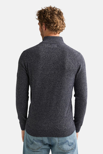 Blue marled turtleneck sweater back view, ribbed cuffs and hem, worn with light blue jeans