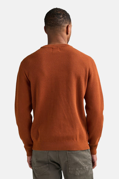 Rust-colored ribbed knit O-neck sweater back view, worn with olive cargo pants, textured fabric, relaxed fit