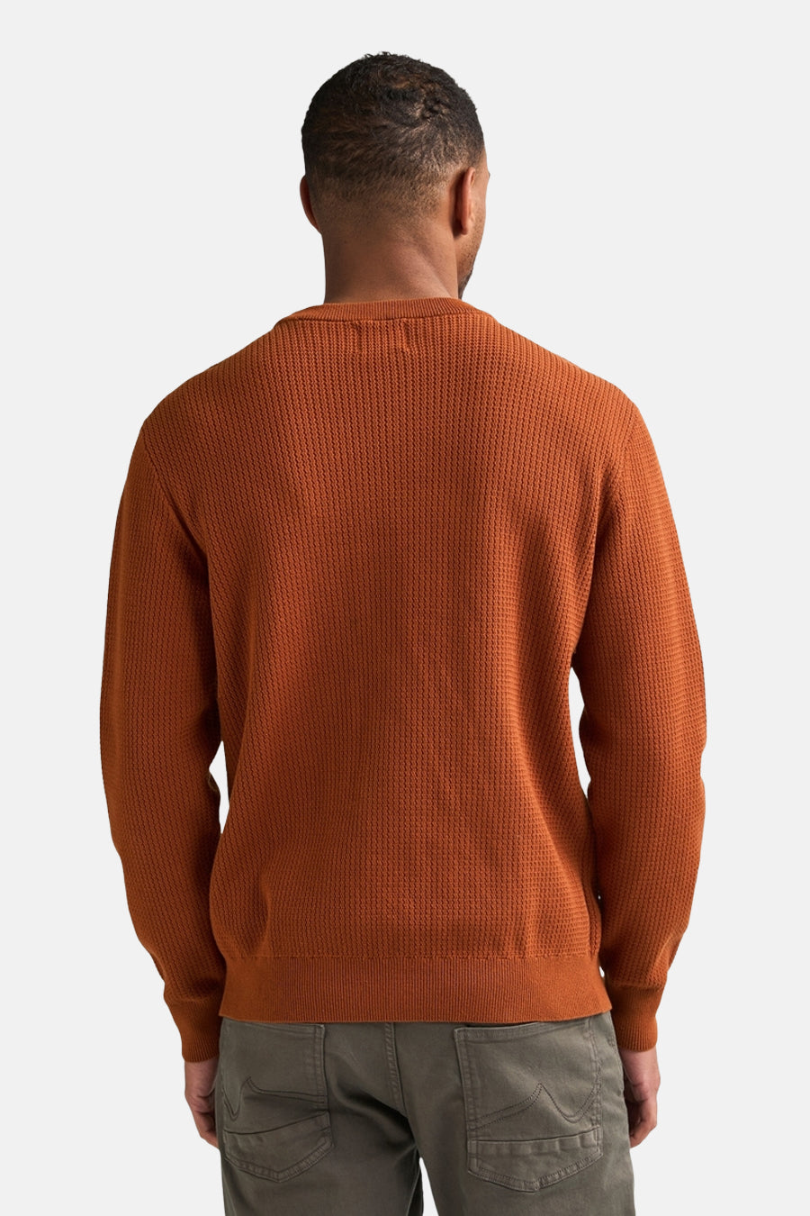 Rust-colored ribbed knit O-neck sweater back view, worn with olive cargo pants, textured fabric, relaxed fit