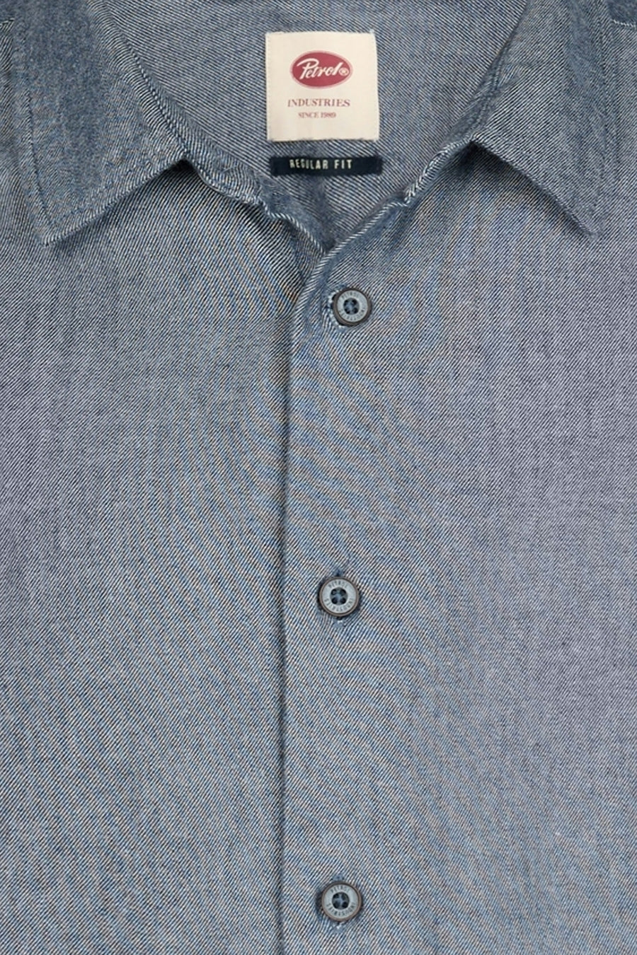 Blue long-sleeve shirt by Petrol Industries, chambray fabric with button-down front and classic collar, close-up view